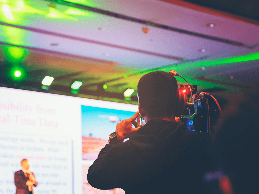 A man is taking a picture at a conference.